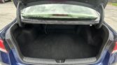 Blue sedan with its trunk open, revealing a spacious cargo area and rear seats.