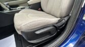 Front passenger seat and center console of a car with beige upholstery and gear shifter visible by the door sill.