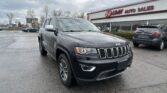 Black Jeep SUV in a parking lot in front of an EZ LOAN Auto Sales storefront on a cloudy day.