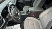 Front interior of a Chevy SUV showing driver and passenger seats, steering wheel, and center console; paper floor mat visible on the driver side.