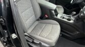 Interior of a car showing the front seats, center console, and gear shifter from the driver's side door.