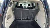 Rear interior of a SUV with the third-row seats upright, showing the cargo area and black upholstery.