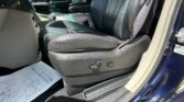 Interior of a car showing the front passenger seat in black leather and a long paper sheet on the floor near the door.