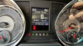 Instrument cluster with digital speed readout at 0 mph, gear in Park, flanked by round analog gauges (tachometer and speedometer). The central display shows Vehicle Speed and a red warning icon below.