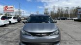 Front view of a silver car in a dealership lot with an EZ LOAN Auto Sales sign on the left.