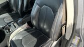 Black leather car seats with white stitching in a vehicle interior, front row, center console visible.