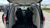 Open rear hatch showing spacious cargo area with folded third-row seats in a minivan/SUV; back row seating visible inside vehicle.
