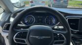 View from driver seat of a car, dashboard and steering wheel in foreground, parking lot with cars outside through the windshield