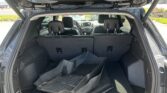 Open SUV trunk with cargo area showing stacked black floor mats behind the rear seats.