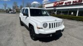 White Jeep SUV parked in a dealership lot in front of EZ LOAN Auto Sales on a sunny day.