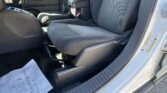 Front seats of a dark cloth-car interior with center console, gear shifter, and passenger door open.