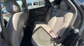 Interior of a gray car showing the rear bench seat with headrests and visible seat belts.