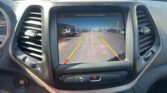 In-car display showing rearview camera view with green, yellow, and red guide lines for parking.