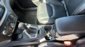 Front passenger-side view of a black leather car interior with stitched seats and center console gear shifter.