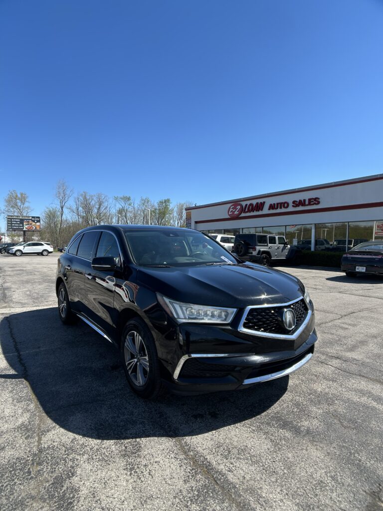 Black SUV in a parking lot in front of an E-Z Loan Auto Sales building under a clear blue sky, showroom vehicles visible in background.