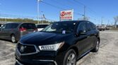 Black SUV in the foreground at EZ Loan Auto Sales lot under a clear blue sky with the dealership sign visible nearby.
