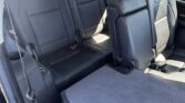 Interior of a black leather SUV with two captain chairs in the second row and a flat folded rear load floor for cargo