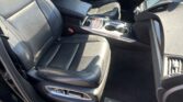 Interior of a right-hand-drive Acura SUV with black leather seats, center armrest, and chrome-trimmed console.