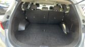 Open SUV hatch revealing spacious cargo area with third-row seats upright and rear seats folded, empty trunk space behind the back row.