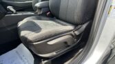 Front interior of a car showing the driver-side seat area, center console with an automatic gear shifter, and a floor mat with footprints near the door sill.