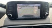 Rearview camera display on car screen showing parking guidelines over a parking lot scene (yellow and red guide lines).
