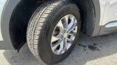 Close-up of a car wheel and tire on a gray SUV, showing the tread and alloy rim in the wheel well.