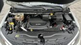 Open car hood revealing the engine bay, including a 3.6L engine cover, coolant reservoir, and battery area.