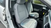 Interior of a car with two gray cloth front seats, center console, and steering wheel visible through the open driver's door.