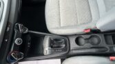 Front interior of a car showing the center console with gear selector (P R N D), climate controls, and a note on the passenger seat.