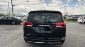 Rear view of a black Chrysler Pacifica SUV in a parking lot with other cars and power lines overhead