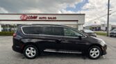 Black SUV parked in front of an E-Z Loan Auto Sales storefront sign towering over the lot.