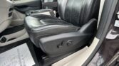 Front interior of a car with black leather seats, center console, and steering wheel visible on the left.