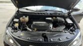Open hood shows the engine bay of a dark SUV, with a 3.6L engine cover in the center and front grille below.