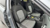 Interior of a car showing the driver and front passenger seats with black-and-gray checkered upholstery and center console nearby.