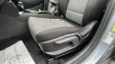 Front interior of a car showing the center console, gear shifter, and plaid-patterned seat fabric.