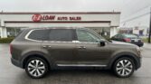 Gray SUV parked in front of the EZ Loan Auto Sales dealership with red sign on a white building in the background
