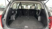 Rear hatch open showing an empty SUV cargo area with three upright black rear seats and a black floor.