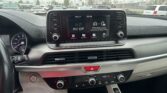 Car dashboard with a center touchscreen showing 'AV Off' and side control buttons in view behind the steering wheel