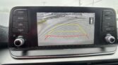 Infotainment screen showing rear-view camera with safety guidelines and colored guide lines for parking.