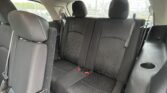 Rear passenger seats in a dark fabric car interior with headrests and seat belts visible across the bench
