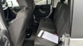 Interior of a dark SUV from the passenger side with front and back seats visible and documents on the rear bench.
