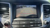 Dashboard touchscreen showing the car's rearview camera feed with colored parking lines (red/yellow) to guide backing up and check surroundings for safety.