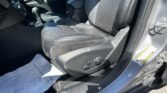 Front interior view of a black leather car seat and center console, passenger door open with Jeep branding on the door sill visible.
