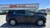 Black Chevrolet Equinox parked in front of an E-Z Loan Auto Sales storefront on a sunny day