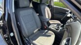 Interior of a car showing driver and front passenger seats with black fabric upholstery and stitching separate from other interior features.