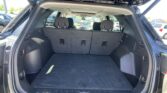 Open SUV tailgate revealing a large, empty cargo area with the rear seats in upright position, parked in a lot.
