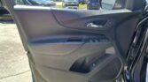Interior of a car door panel with a chrome handle, window controls, and side mirror visible through the open door