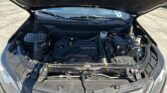Open car hood exposing the engine bay, with an Ecotec engine cover and visible battery and fluid reservoirs