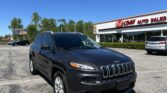 Front view of a dark SUV parked in a dealership lot with an EZ LOAN AUTO SALES building in the background.