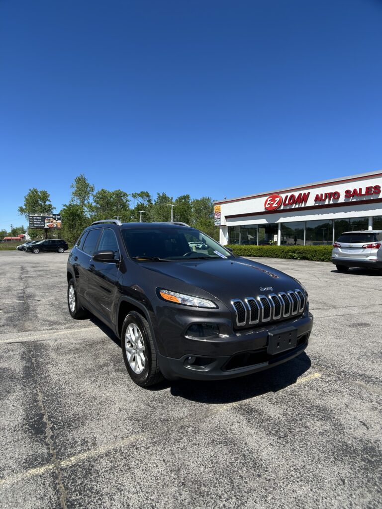 Front view of a dark SUV parked in a dealership lot with an EZ LOAN AUTO SALES building in the background.